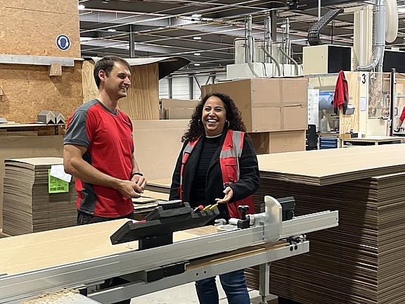 Mitarbeiter im Gespräch mit einer Hofmann-Personalbetreuerin in der Produktionshalle des Verpackungsherstellers