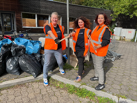 Drei lächelnde Mitarbeiter von Hofmann Personal, die beim World Cleanup Day in Langwasser tatkräftig geholfen haben.
