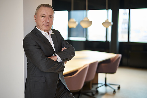 Mitglied des Executive Committee in Businesskleidung vor einem modernen Konferenzraum