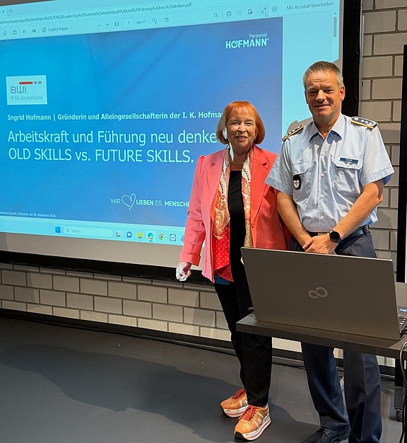 Ingrid Hofmann, Geschäftsführerin von Hofmann Personal, steht lächelnd neben einem Mann beim Leadership Summit 2026.