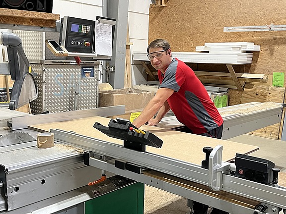 Mitarbeiter an einer Holzverarbeitungsmaschine in einer Werkhalle, unterstützt durch Hofmann Personal und TRICOR