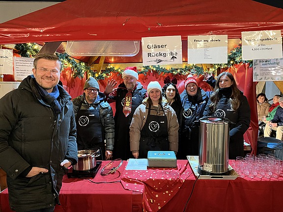 Gruppenfoto mit Oberbürgermeister Marcus König am Stand von Hofmann Personal beim Weihnachtsmarkt Langwasser.